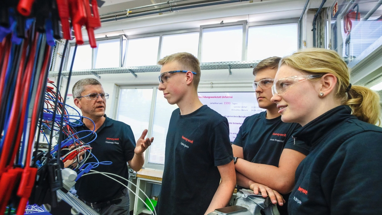 junge Auszubildende lernen eine Roboteranlage zu bedienen