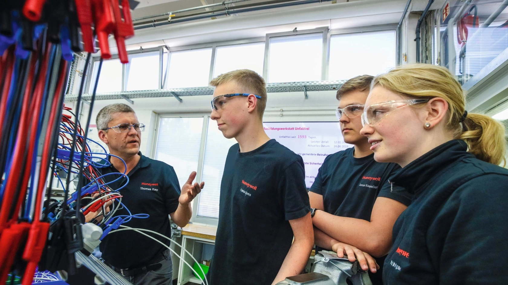 junge Auszubildende lernen eine Roboteranlage zu bedienen